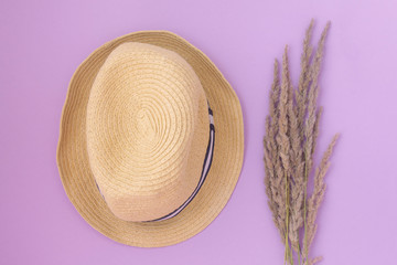 straw hat and wildflowers on a pink background. summer concept. Flat lay