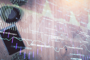 Multi exposure of financial chart hologram over desktop with phone. Top view. Mobile trade platform concept.