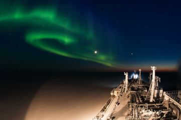 Night shot of the icebreaking LNG carrier and aurora borealis