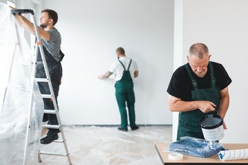 Professional renovation crew painting walls of new build apartment