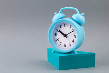 Alarm clock on grey background - time concept.