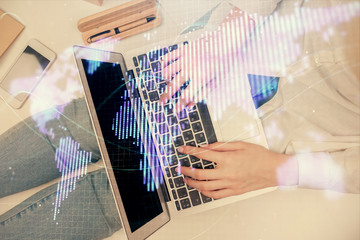 Double exposure of woman hands working on computer and financial theme hologram drawing. Top View. Business concept.