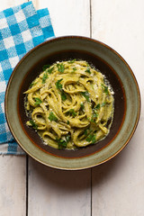 Creamy green pasta with poblano pepper and parmesan cheese on white background