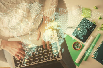 Double exposure of woman hands working on computer and financial theme hologram drawing. Top View. Business concept.