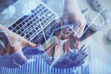 Double exposure of businesswoman hands typing on computer and financial graph hologram drawing. Stock market analysis concept.