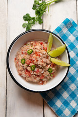 Canned tuna ceviche with chili pepper and tomato on white background