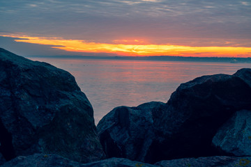 Sunset over the sea between the rocks