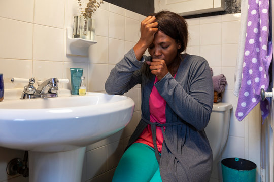 Young coughing woman in the bathroom feeling ill 