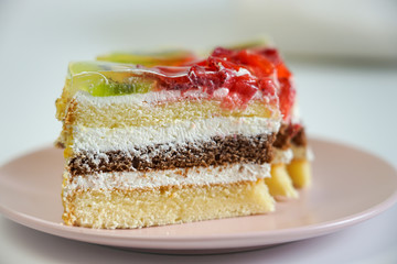 a piece of puff pastry cake with strawberries and kiwi is on a plate