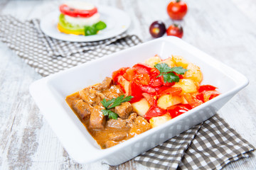 cooked meat with tomatoes and potatoes