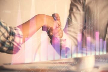 Fototapeta premium Double exposure of forex graph hologram and handshake of two men. Stock market concept.