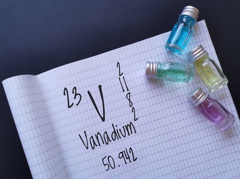 Vanadium is a chemical element of the periodic table with the symbol V and atomic number 23. The symbol V with atomic data and colored vanadium aqueous solutions in glass bottles.