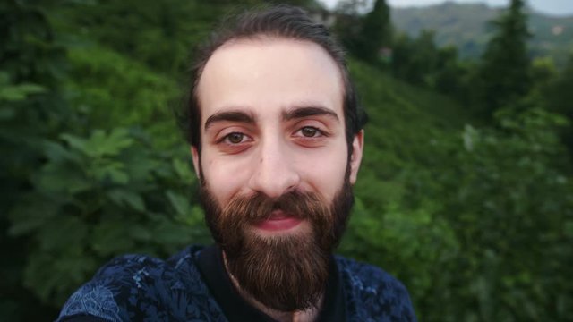 Young and long bun hair and long beard hipster man with making video call with camera in hands pow planYoung and long bun hair and long beard hipster man with making video call with camera in hands
