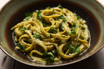 Creamy green pasta with poblano pepper and parmesan cheese on white background