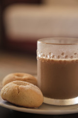 Cookies and coffee in a white plate. Coffee with milk in glass cup. Homemade cookies.