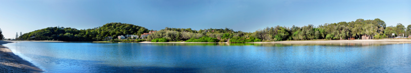 Large panoramic image of a lake in bright sunny day