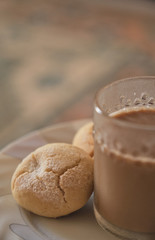 Cookies and coffee in a white plate. Coffee with milk in glass cup. Homemade cookies.