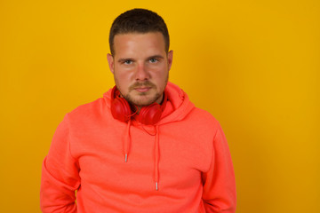 Fototapeta premium Portrait of outraged young man with oval face, blue eyes wearing White T-shirt frowning his eyebrows being displeased with something. Scowling pretty female isolated over grey.