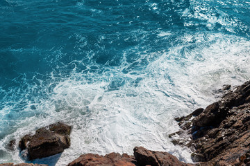 Rocky seashore with crushing foamy waves