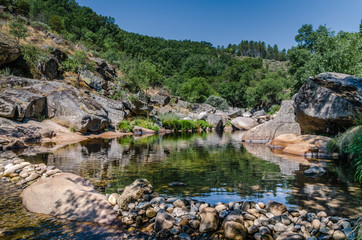 A small lake reflecting the environment in the Natural Park of Las Batuecas, Salamanca, Spain