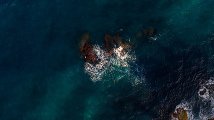 waves hitting two small rocks in top view , mediterranean sea , Spain , aerial view 