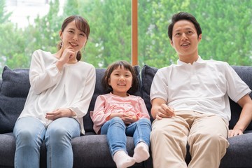 ソファでくつろぐ親子三人　アジア人