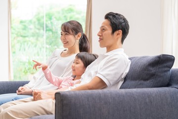 ソファでくつろぐ親子三人　アジア人