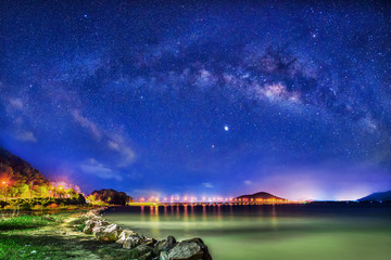 Milky Way galaxy, on Bridge over the lake, Long exposure photograph, with grain.Image contain certain grain or noise and soft focus.