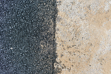 New and old asphalt at the compound. Black and light gray. Concept of opposition, comparison.
