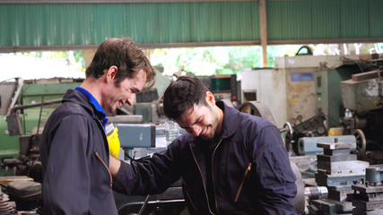 Tired factory workers taking a break and talking to coworker in the factory . Industry and...