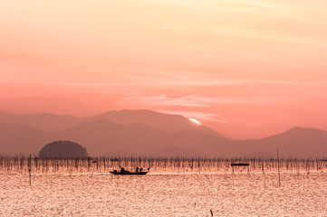 The beautiful seascape of ocean sunset background mountain and orange color clouds.