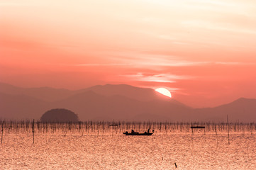 The beautiful seascape of ocean sunset background mountain and orange color clouds.