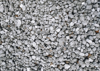 Obraz premium Slag in the form of small gray stones, top view. Waste rock during iron ore mining.