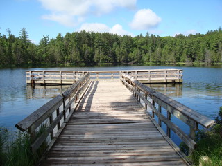 T-Shaped dock in the sunlight on a small lake