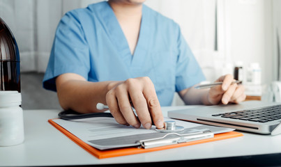Fototapeta premium Healthcare costs and fees concept.Hand of smart doctor used a calculator for medical costs in modern hospital