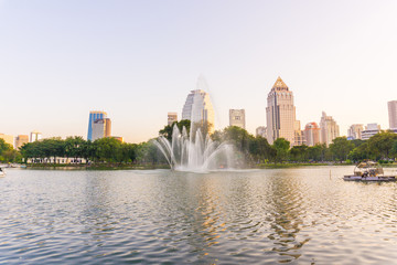 Lumpini park business district Bangkok cityscape from park with sunset sky