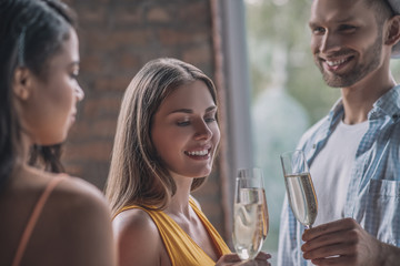 Three smiling friends having a good party together