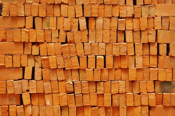 Fototapeta premium Clay bricks stacked in irregular rows abstract horizontal background texture
