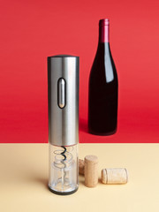 Electric corkscrew for wine opening. Nearby are corks from wine bottles..In the background there is...