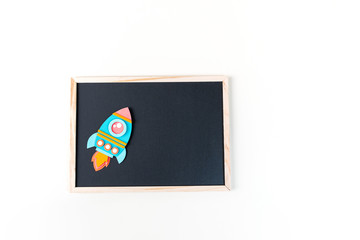 Obraz premium Rocket paper craft. Back to school education. Black chalkboard background