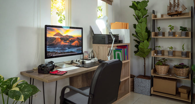 Small homeoffice for photographer with plants decor and Bromo Mt picture on the destop wall paper
