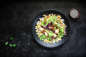 Healthy fruit and vegetable salad, lettuce, corn, grapes, apples on plate. Diet menu. Top view.