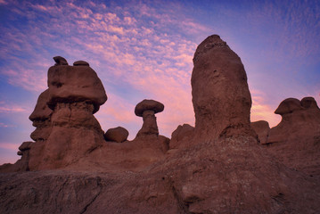 Goblin hoodoos under pink clouds in goblin valley Utah.