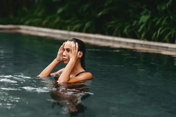 Retreat and vacation. Beautiful young woman relaxing in spa swimming pool.
