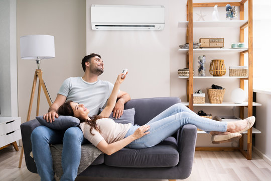 Happy Woman Holding Air Conditioner Remote