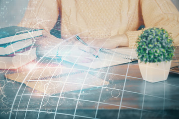 Double exposure of hands making notes with world map hologram and data theme icons. Concept of global computer data.