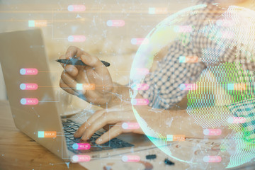 Multi exposure of world map hologram with man working on computer on background. Concept of worldwideweb.