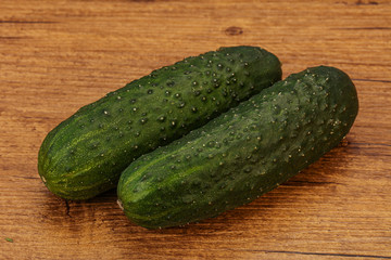 Green fresh cucumbers over background