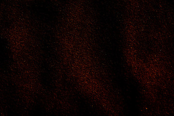 Fototapeta na wymiar Red shiny dust on a black background. Flying sparkles.