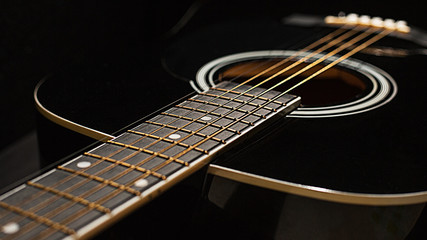 Fototapeta premium Fretboard, strings and acoustic guitar on a black background